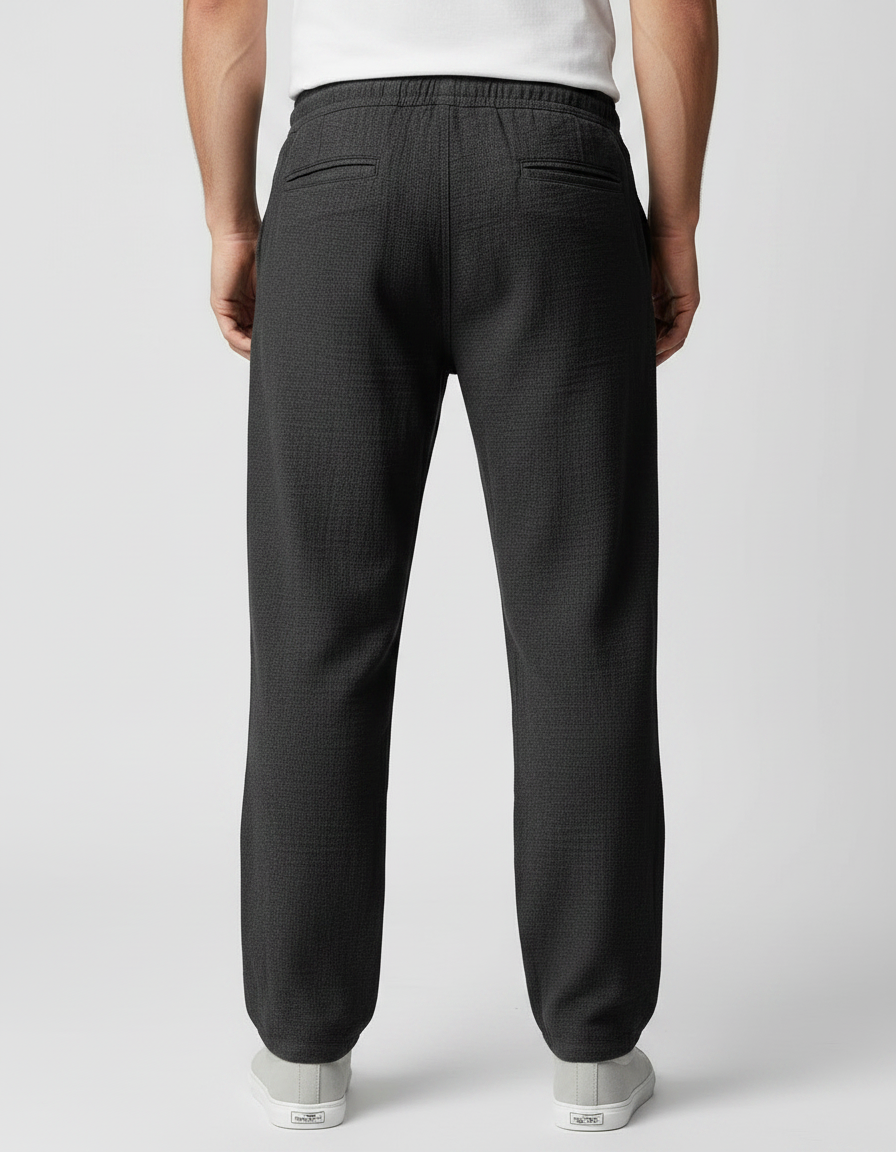 Men's casual trousers in grey shown from the side, highlighting relaxed silhouette